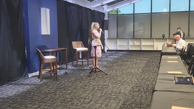 Alissa Mastropietro holding a microphone while hosting an event